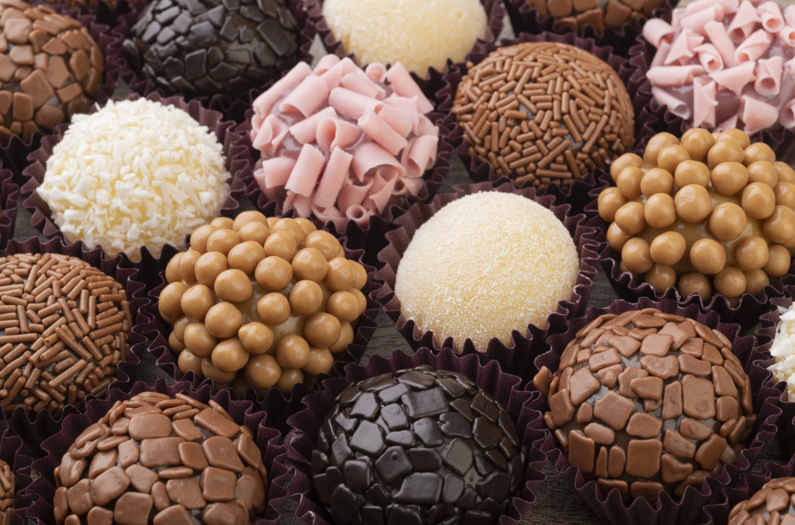 Typical brazilian brigadeiros, various flavors over wooden table