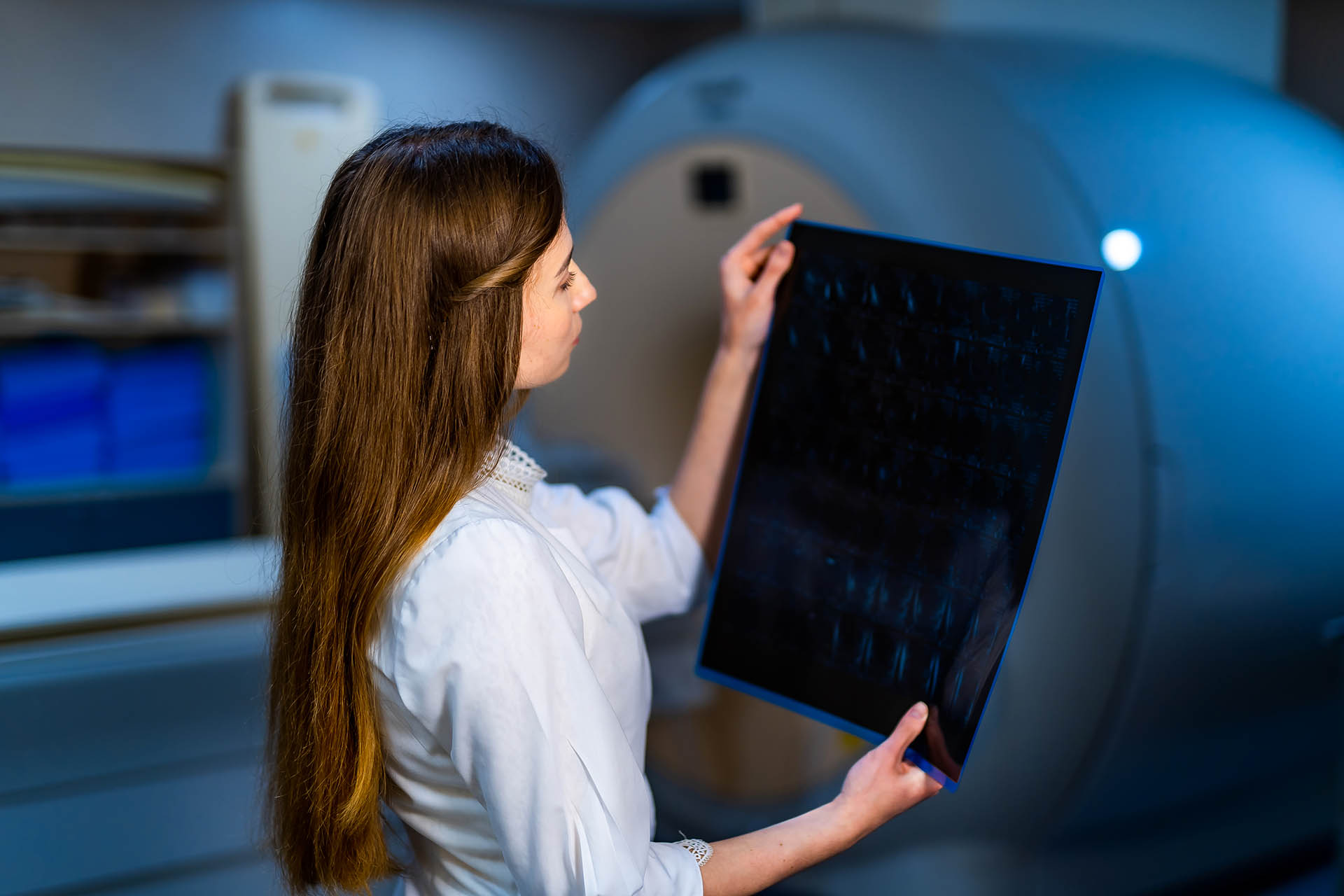 Competent doctor reading x-ray near the magnetic resonance imaging machine.
