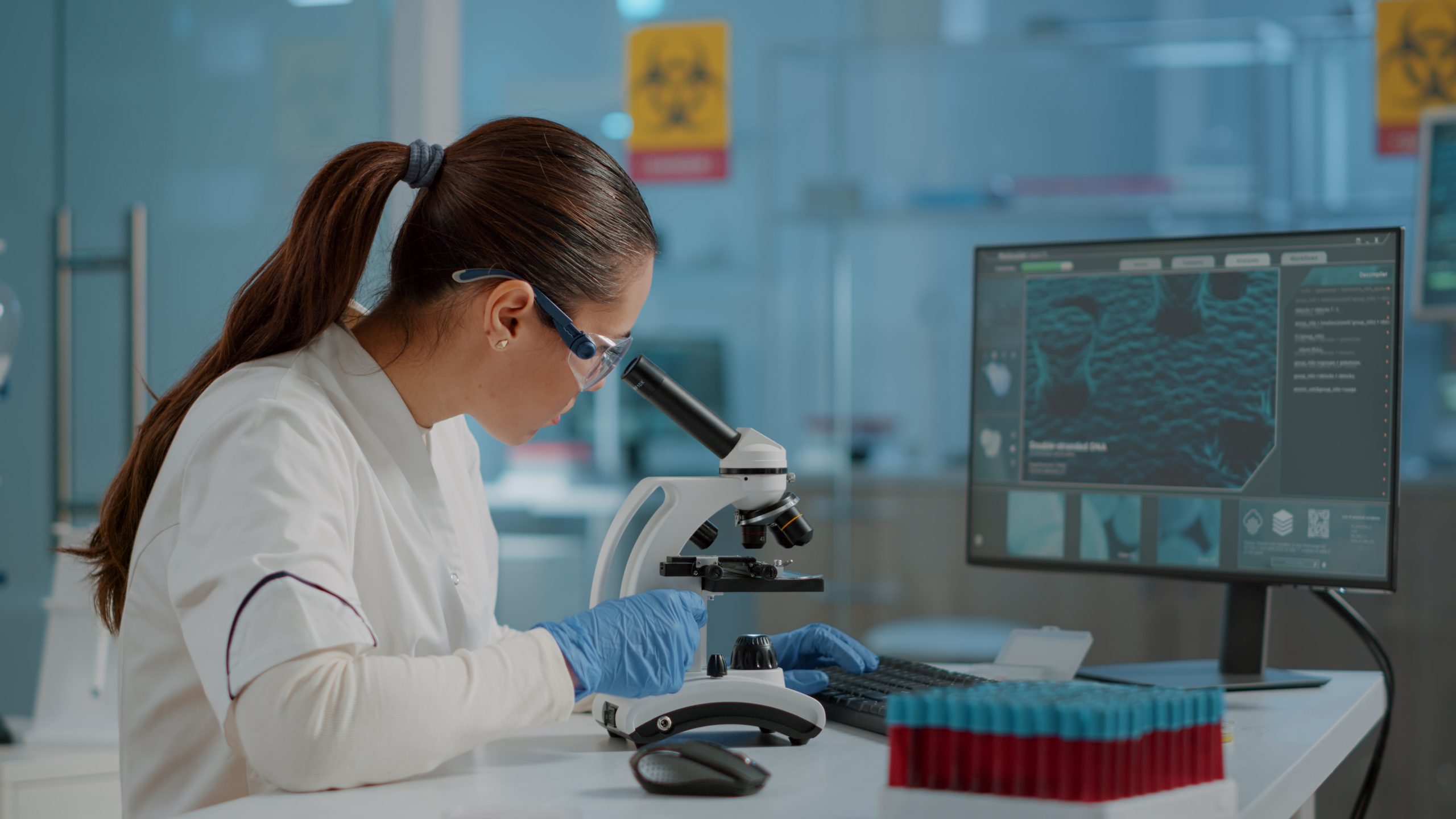 Science engineer using microscope to analyze dna sample