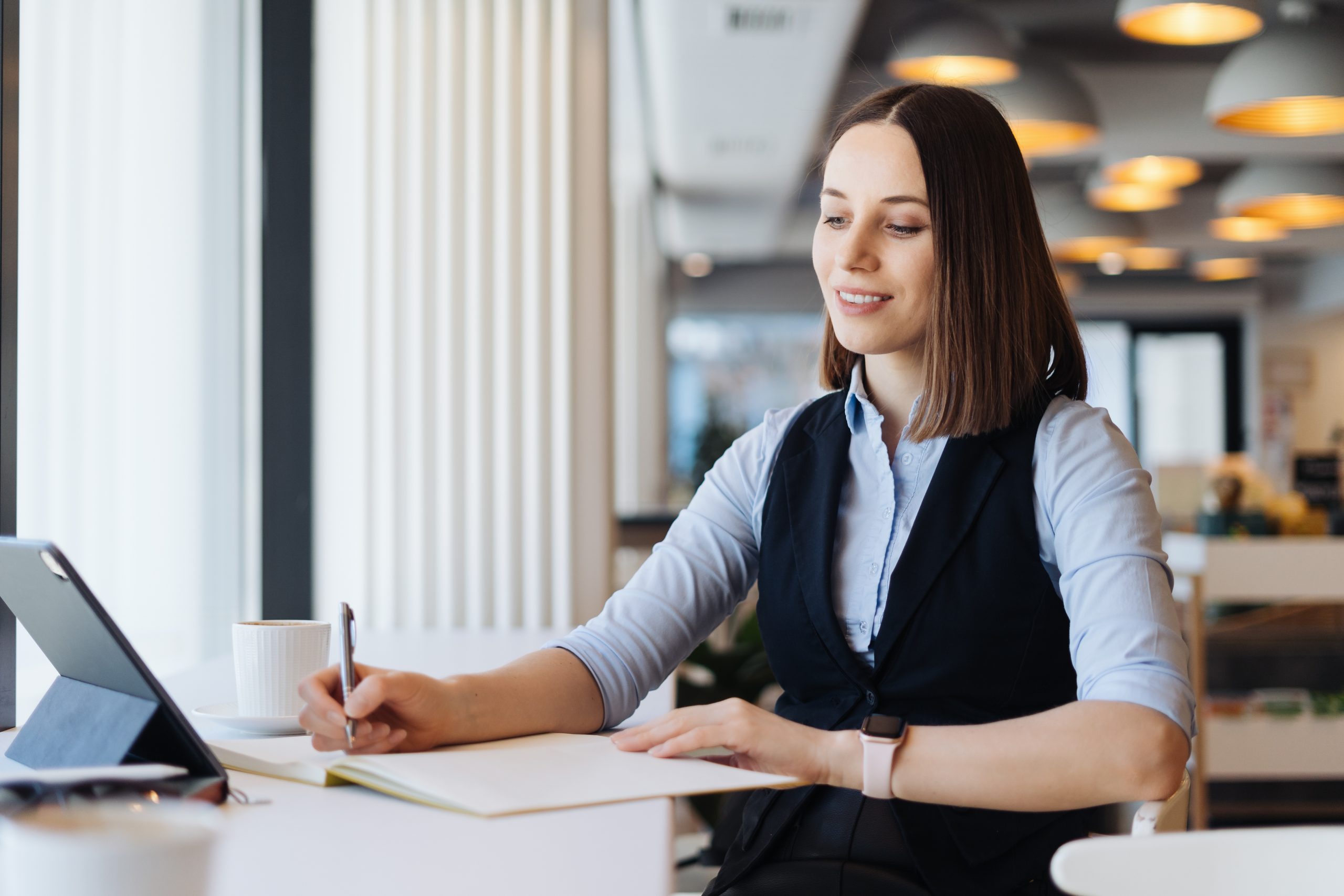 Woman making notes while sitting alone at the table
